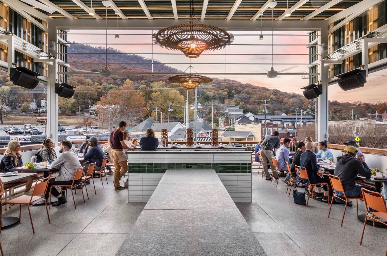 A shot of the covered patio of local Chattanooga restaurant, Little Coyote. There are people sitting on the balcony enjoying meals of smoked meats and tortillas.